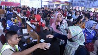 Mahasiswa Sekolah Tinggi Perhubungan Darat (STPD) membantu pemudik yang akan membeli tiket kapal Roll on-Roll (Ro-Ro) di loket pembelian tiket pelabuhan penyebrangan Bakauheni, Lampung Selatan, Lampung, Selasa (19/6). ANTARA FOTO/Ardiansyah.