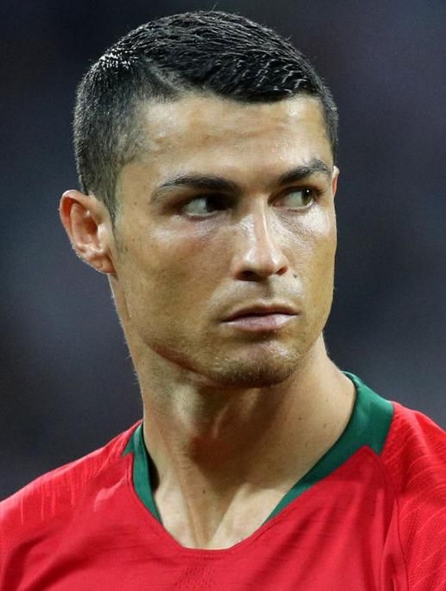 Cristiano Ronaldo kali ini memiliki potongan rambut pendek nan rapi. Tapi dia menyelipkan gaya kekinian dengan aksen skin yang seperti belahan pinggir. Seperti penampilan rambutnya saat bertanding untuk Portugal Vs Spanyol. Foto: Getty Images