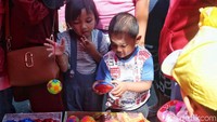 Beberapa anak mengecek mainan yang akan dibelinya.