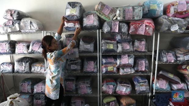 Pekerja saat menyetrika pakaian laundry di tempat  jasa cuci setrika  pakaian Jakarta, Rabu (20/6). Tingginyan kebutuhan akan mencuci dan menyetrika pakaian di saat libur lebaran atau Idul Fitri membuat berbagai usaha Laundry kebanjiran order jasa mencuci dan menyetrika hingga 90% ketimbang hari biasa. Dalam sehari laundry mampu menampung hingga ratusan kilo pakaian. Menurut pegawai laundry, musim libur panjang ini juga membuat jasa laundry mampu meraih untung hingga 5 juta dalam 2 hari. Jasa laundry menjadi alternatif membantu menyelesaikan pekerjaan rumah, apalagi saat bulan libur lebaran. Karena banyak dari mereka yang memiliki asisten rumah tangga belum pulang dari kampung halaman. (CNBC Indonesia/Muhammad Sabki)