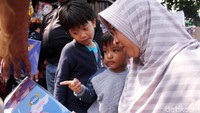 Para orang tua menemani anaknya membeli mainan di Pasar Gembrong.