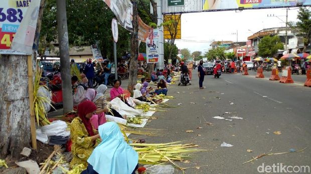 Para pedagang janur dan selongsong ketupat berjualan di pinggir jalan