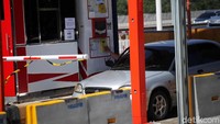 Pengendara melakukan pembayaran di gerbang tol Pasar Rebo menggunakan uang elektronik.