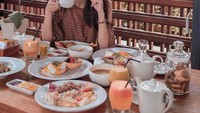 Gigit roti dan pegang cangkir kopi, ini sarapan terakhir Gani sebelum plesiran ke Vietnam. Sarapannya lengkap banget ya? Foto: Instagram ganegani