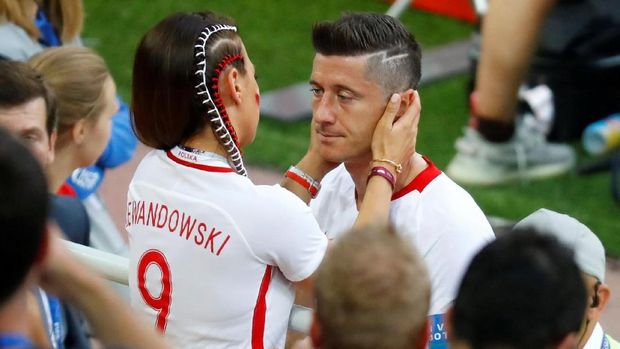 Pemain Polandia Robert Lewandowski dan isterinya Anna usai takluk dari Senegal, di Spartak Stadium, Moscow, Rusia, 19 Juni.