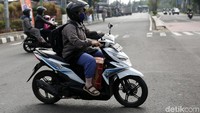 Pemudik motor membawa barang bawaan berupa tas dan kardus.