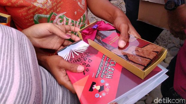 Selain kain batik, Jokowi juga membagikan buku kepada warga 