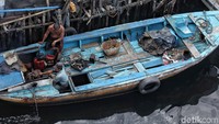 Seperti ini salah satunya. Salah seorang nelayan tampak sedang memperbaiki mesin kapalnya.