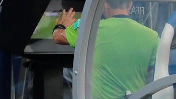 Penampakan wasit saat memanfaatkan referee review area (RRA), satu fasilitas VAR, untuk melihat kembali sebuah kejadian pada pertandingan. Foto: REUTERS