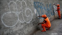 Petugas PPSU tengah membersihkan coretan vandalisme di kawasan Tendean, Mampang, Jakarta, Jumat (22/6/2018).