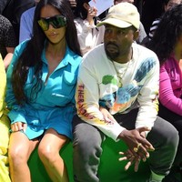 Di luar aksesori yang sederhana, untuk fashion show Louis Vuitton Kim tampil mencuri atensi dengan jaket LV warna biru neon yang ia padukan bersama celana ketat yang sudah jadi ciri khasnya. Di sampingnya, Kanye memakai statement sweater dan trackpants. Foto: Dok. Getty Images
