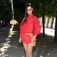 Model Bella Hadid memilih gaun bergaya athleisure merah dengan siluet bervolume yang dipadu dengan heels berwarna senada. Sebagai pelengkap gayanya, adik Gigi Hadid itu mengandalkan tas pinggang yang menyerupai sarung pistol. (Foto: Getty Images)