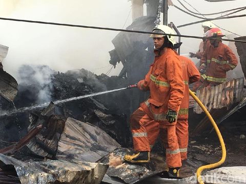 Asap di lokasi masih pekat, petugas masih menyemprot air untuk memastikan api benar-benar mati
