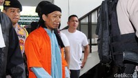 Aman Abdurrahman meninggalkan Pengadilan Negeri Jakarta dengan tangan diborgol.