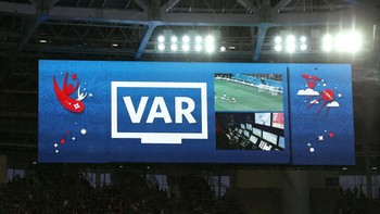 Tampilan lain saat VAR sedang melakukan peninjauan rekaman ulang suatu kejadian di kotak penalti saat Rusia melawan Mesir. Foto: Getty Images