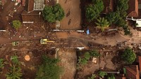 Warga dan relawan membersihkan rumahnya dari material pasir dan lumpur akibat banjir bandang di Desa Alas Malang, Singojuruh, Banyuwangi, Jawa Timur, Sabtu (23/6). ANTARA FOTO/Zabur Karuru.
