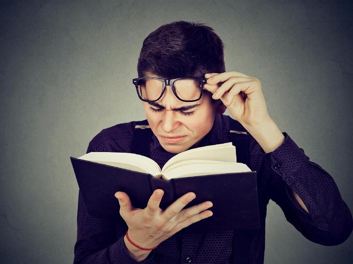 Woman with eyesight problems trying to read on line content in a laptop at home