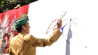 Jokowi saat menggoreskan lukisan karyanya.