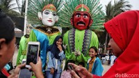 Warga berfoto dengan ondel-ondel.