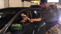 Polisi membagi-bagikan bunga kepada pengendara wanita di jalanan Arab Saudi, Minggu (24/6/2018) dini hari, saat dekrit kerajaan yang membolehkan wanita menyetir mulai berlaku. Foto: Al Arabiya