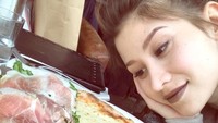 Pose Millane yang satu ini mirip orang jatuh cinta ya? Kali ini dia jatuh cinta pada pizza bertopping keju di Paris. Nyamm! Foto: Instagram millanefernandez