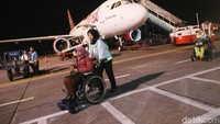 Petugas Angkasa Pura (AP) I juga membantu mendorong kursi roda penumpang disabilitas.