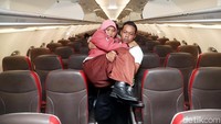 Petugas Angkasa Pura (AP) I membantu menurunkan penumpang disabilitas.