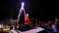 Seorang pendukung Erdogan menyalakan suar. REUTERS/Kemal Aslan.