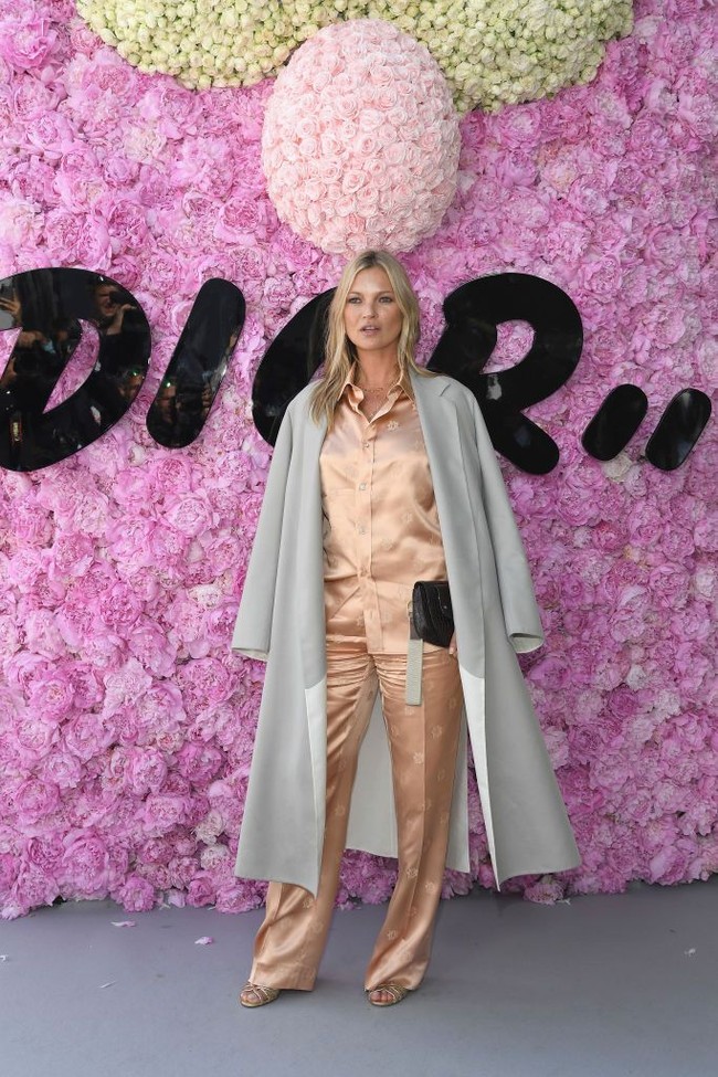 Ikut memaksimalkan gayanya, coat abu-abu bergaya minimalis yang diperlakukan seperti jubah.  Tidak ketinggalan handbag hitam Dior. Foto: Getty Images
