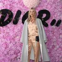 Ikut memaksimalkan gayanya, coat abu-abu bergaya minimalis yang diperlakukan seperti jubah.  Tidak ketinggalan handbag hitam Dior. Foto: Getty Images
