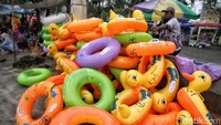 Suasana ramai di Pantai Ancol membuat pedagang ban meraup untung karena banyak pengunjung yang menyewa ban untuk anak-anaknya berenang.