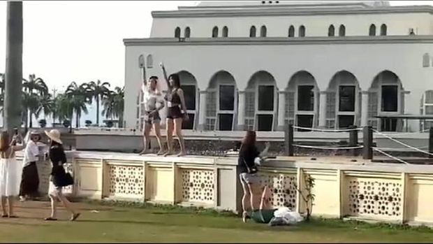 Dua turis wanita terekam kamera sedang menari di luar masjid Malaysia