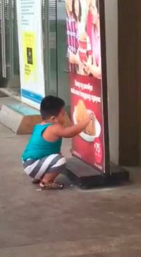 Gemas! Anak Kecil Ini Berusaha Memakan Ayam Goreng dari Papan Iklan