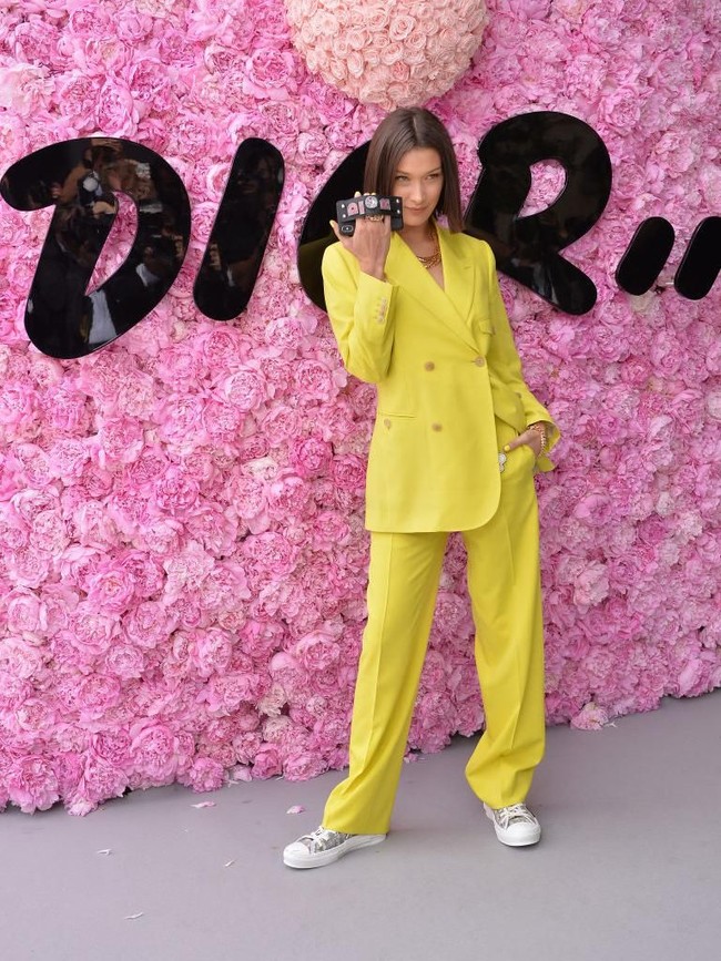 Selain Kate Moss dan Naomi Campbell, hadir pula Bella Hadid yang mewakili generasi model zaman now. Setelan kuning terang dengan jas bergaya double-breasted menjadi pilihannya. Foto: Getty Images