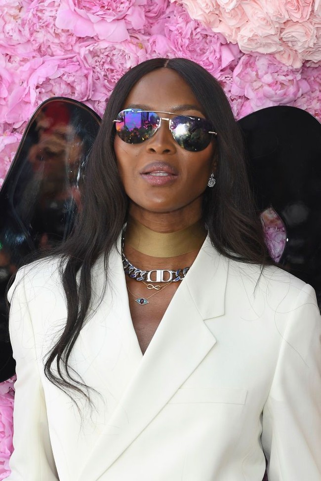 Memakai jas satu kancing dengan model menyilang, gaya maskulin Naomi ini tak terasa monoton. Ia lalu menyempurnakan gayanya dengan kalung choker tembaga dan kalung rantai Dior, berikut kacamata hitam aviator. Foto: Getty Images