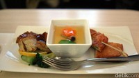 Beberapa menit setelah take-off, traveler akan disuguhi menu makanan ringan seperti ayam dengan saus manis dan juga fish cake. (Dina/detikTravel)