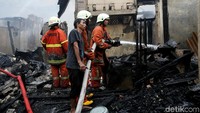 Warga turut membantu petugas damkar memadamkan api.