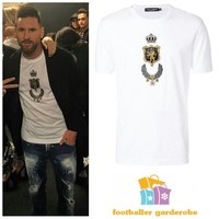Sekilas kaus putih yang dipakai Lionel Messi ini terlihat simpel. Nyatanya harga kaus dengan gambar singa emas di bagian dada itu tak sesederhana penampilannya. Messi memakai kaus dari Dolce & Gabbana seharga US$ 375 atau sekitar Rp 5,3 juta. Foto: Dok.Instagram @footballergarderobe