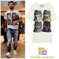 Lionel Messi tampil menarik perhatian dengan kaus putih bergambar harimau mengaum. Kaus yang dipakai pesepakbola 31 tahun ini datang dari brand Gucci seharga US$ 505 atau sekitar Rp 7,2 juta. Foto: Dok.Instagram @footballergarderobe