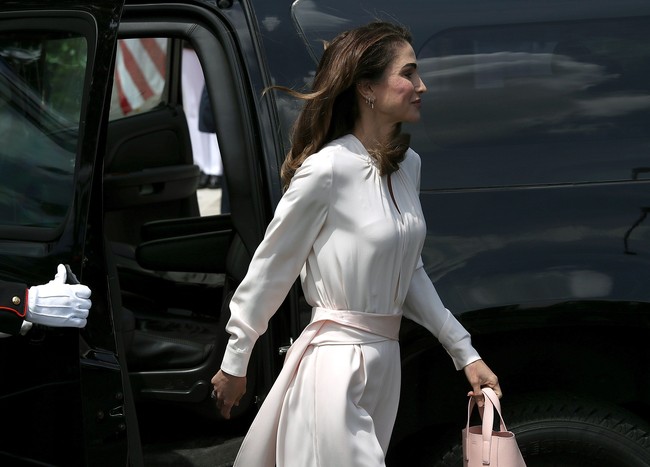 Ratu Rania mengenakan busana bernuansa monokrom, warna pink pucat dari atas sampai bawah. Ia mengenakan blouse dan celana wide leg berlabel Adeam, tas hingga sepatu pumpnya pun berwarna pink. Foto: Dok. Getty Images