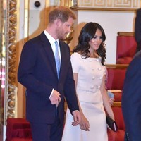 Untuk momen istimewa tersebut, Meghan memesona dalam balutan two-piece dress merah muda pastel dari Prada. Atasannya hadir dengan model kancing ganda (double-breast) serta garis leher bergaya off-shoulder yang mengekspos sebagian pundaknya. (Foto: Getty Images)