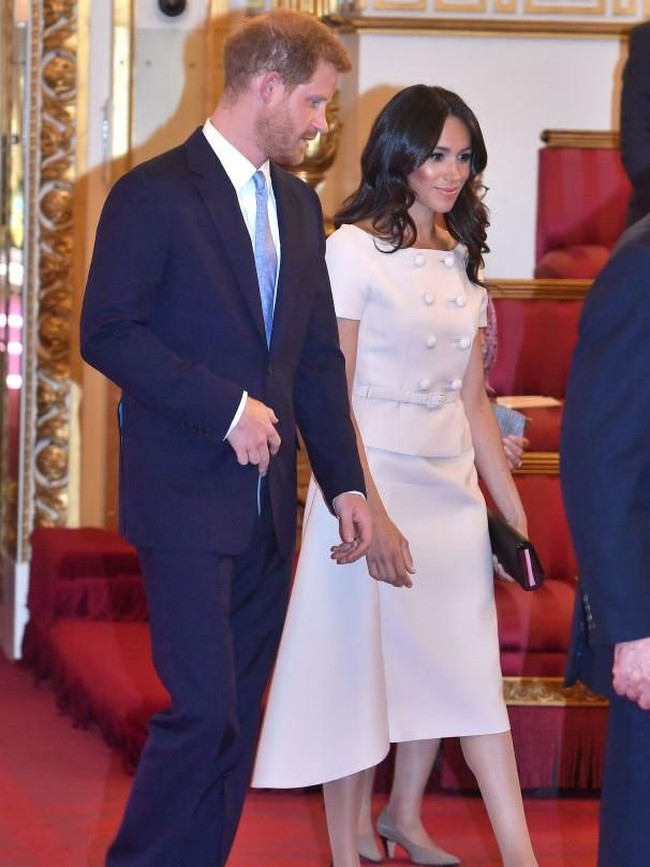 Untuk momen istimewa tersebut, Meghan memesona dalam balutan two-piece dress merah muda pastel dari Prada. Atasannya hadir dengan model kancing ganda (double-breast) serta garis leher bergaya off-shoulder yang mengekspos sebagian pundaknya. (Foto: Getty Images)