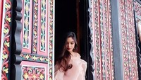 Sering keliling dunia, tetapi juga suka eksplor negeri sendiri. Inilah gayanya saat di rumah gadang Bukittinggi (syandria/Instagram)