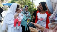 Nurul Arifin sempat menggendong dan mencium bayi warga.