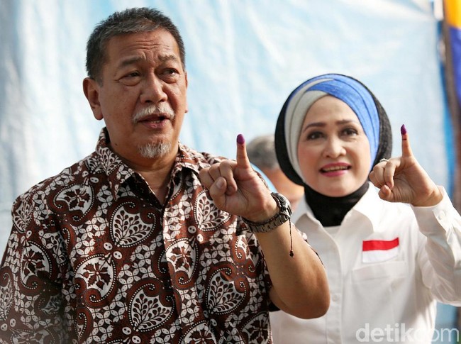 Kemeja batik menjadi pilihan Deddy Mizwar saat mencoblos bersama istrinya, R. Giselawati, di TPS 61, Jatiwaringin, Bekasi, Jawa Barat. Kemeja batik kecoklatan tersebut tampak mencolok dengan motif kawung yang ditimpa dengan motif bernuansa floral. (Foto: Agung Pambudhy)