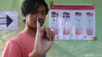Seorang warga menunjukkan jari kelingking yang telah dicelupkan ke tinta.