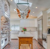 Material batu bata juga menjadi aksen untuk interior dapur. Area dapur dilengkapi meja island di bagian tengah untuk mengakomodasi kegiatan masak-memasak. Tampak warna putih masih mendominasi. (Foto: Dok. Variety)