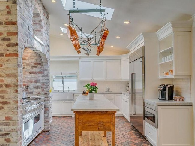 Material batu bata juga menjadi aksen untuk interior dapur. Area dapur dilengkapi meja island di bagian tengah untuk mengakomodasi kegiatan masak-memasak. Tampak warna putih masih mendominasi. (Foto: Dok. Variety)