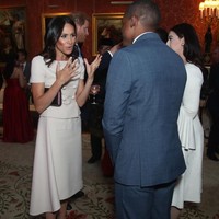 Turut menyempurnakan gaya sang Duchess of Sussex, sebuah sabuk mungil di atas pinggul. Tidak ketinggalan pointed-heels hitam beraksen pita di belakang dari Aquazzura dan clutch Prada berwarna senada. (Foto: Getty Images)