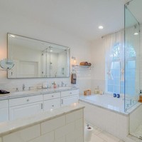 Kamar mandi utama yang hadir dengan bathtub dan shower. Pemakaian keramik putih sebagai dinding menciptakan kesan chic. (Foto: Dok. Variety)